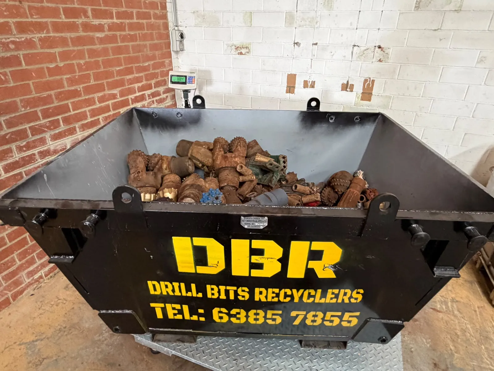 Drill Bits Recyclers collection bin loaded with worn drill bits sitting on the depot scale