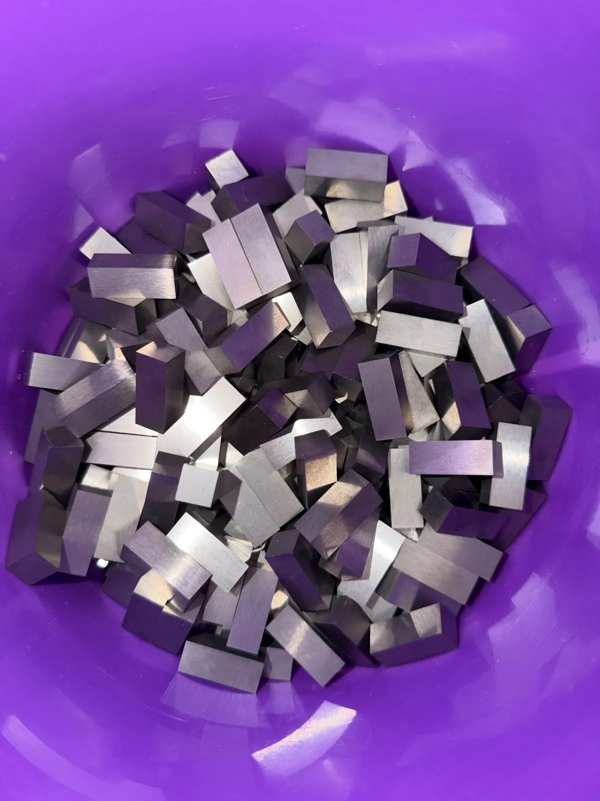 Brushed tungsten alloy bar blanks in a bucket