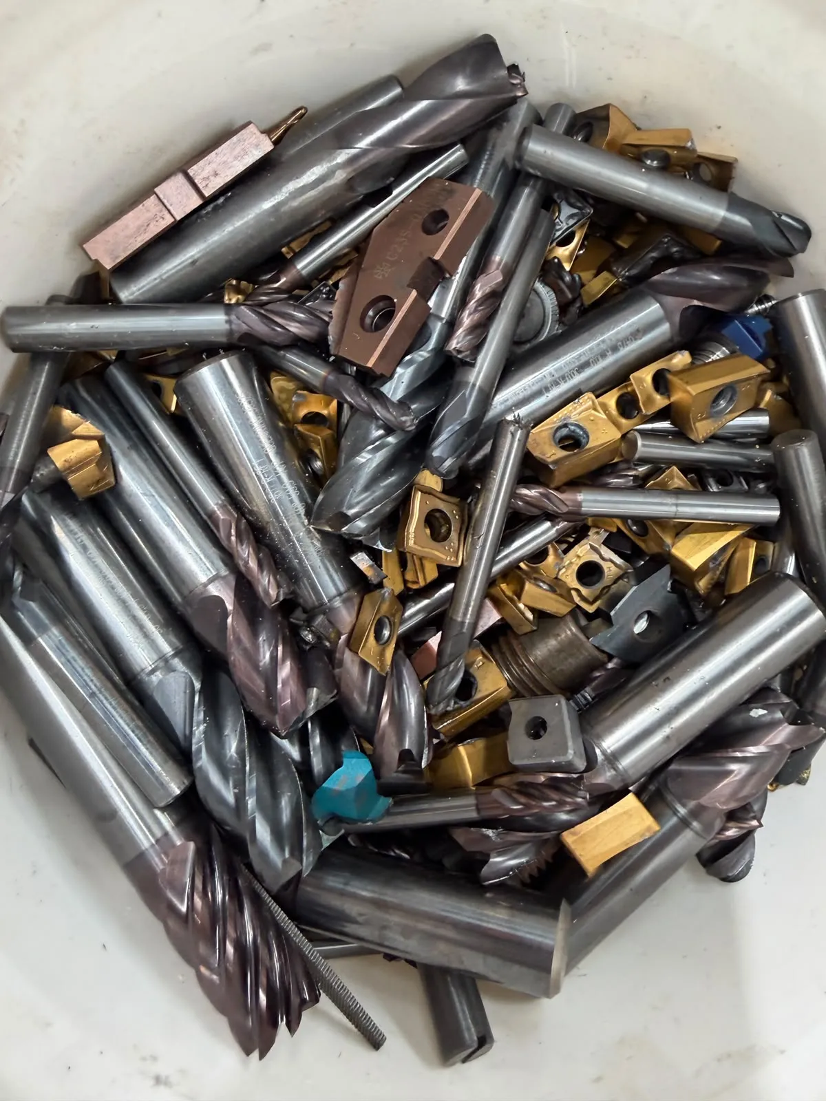 Worn carbide end mills, taps and inserts in a bucket