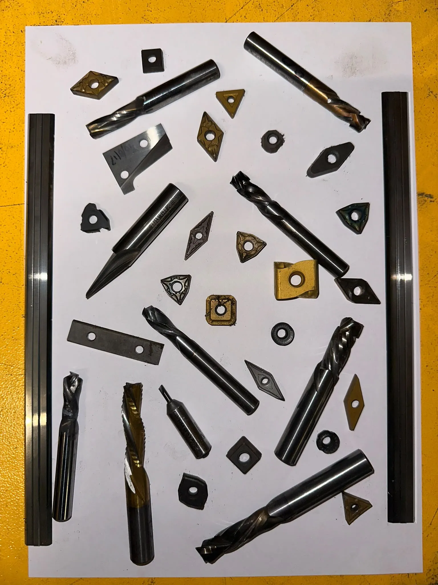 End mills, drills and inserts laid out for assessment