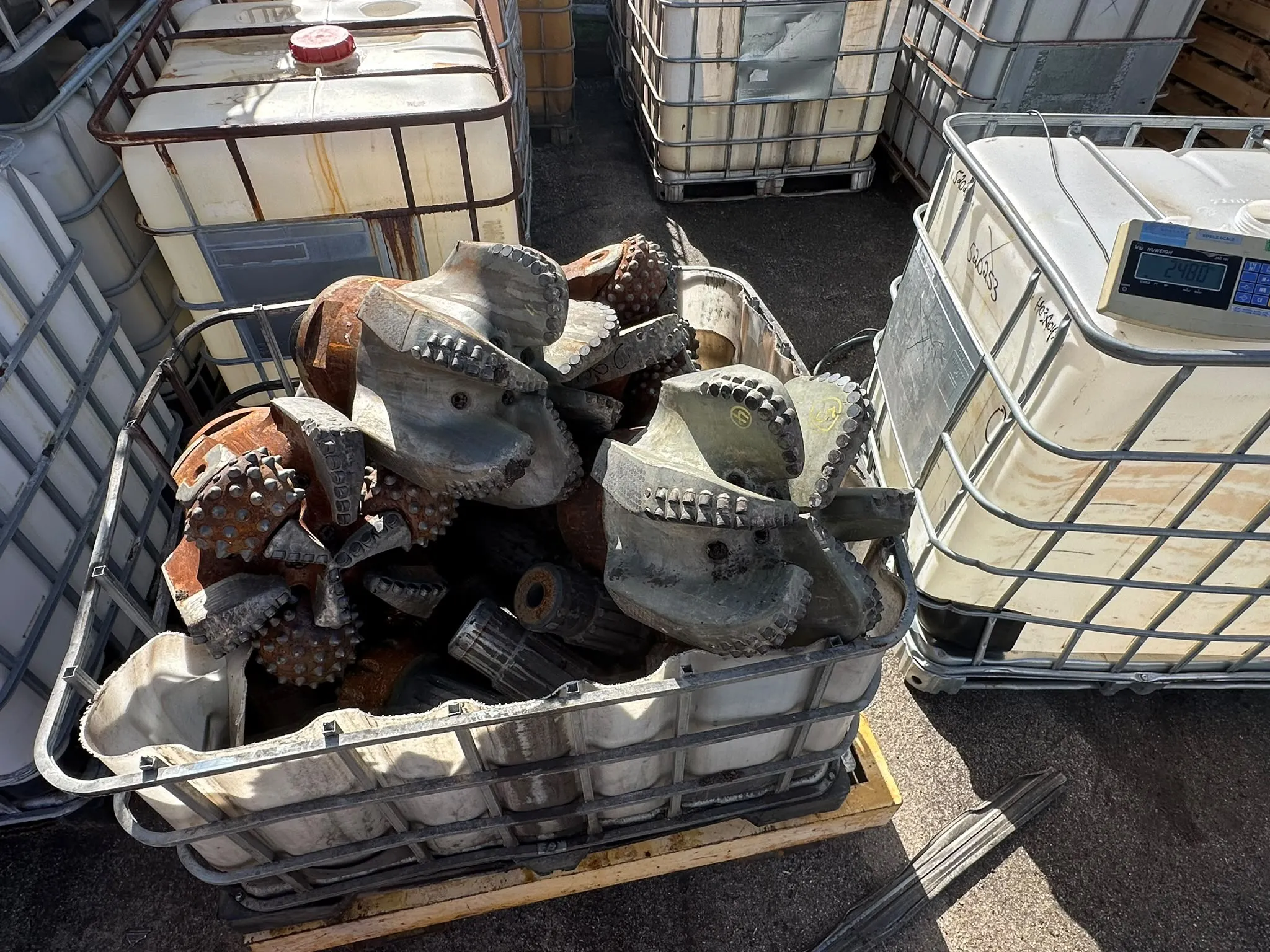 Crate of large PDC and tricone bits staged for assessment