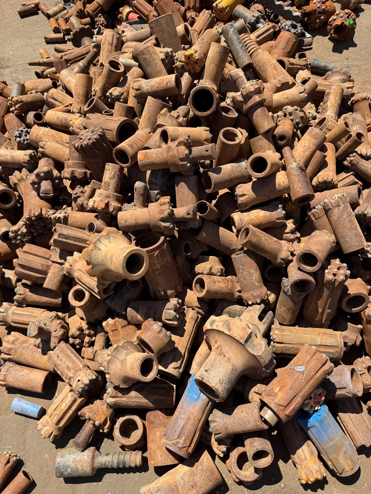 Bulk pile of worn drill bits and hammers recovered from mine site work