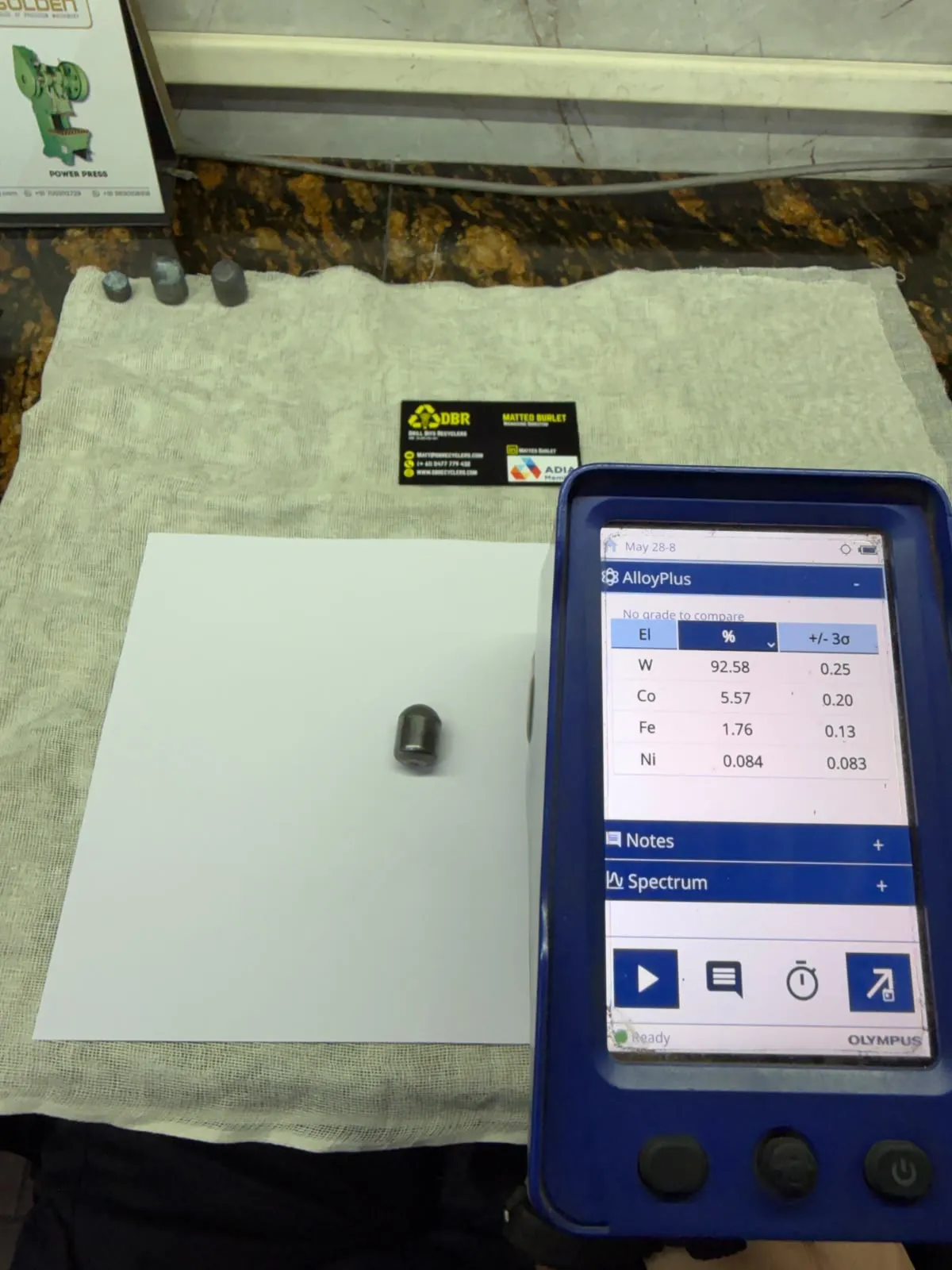 Handheld XRF analyser reading the composition of a single carbide button